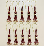 Set of red and gold tassel decorations on a beige background