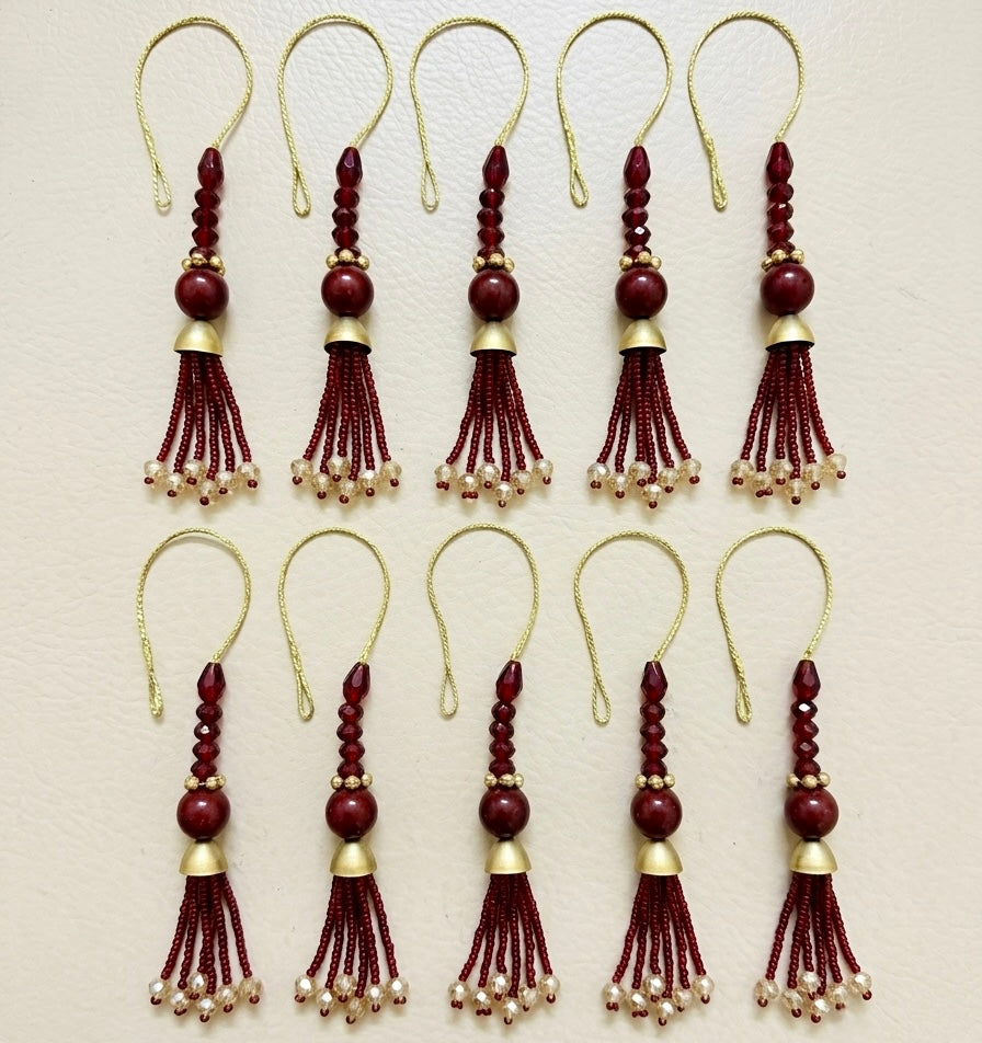 Set of red and gold tassel decorations on a beige background