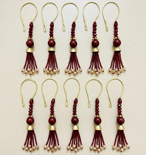 Set of red and gold tassel decorations on a beige background