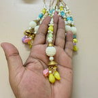 Colorful beaded necklace held in a hand against a beige background