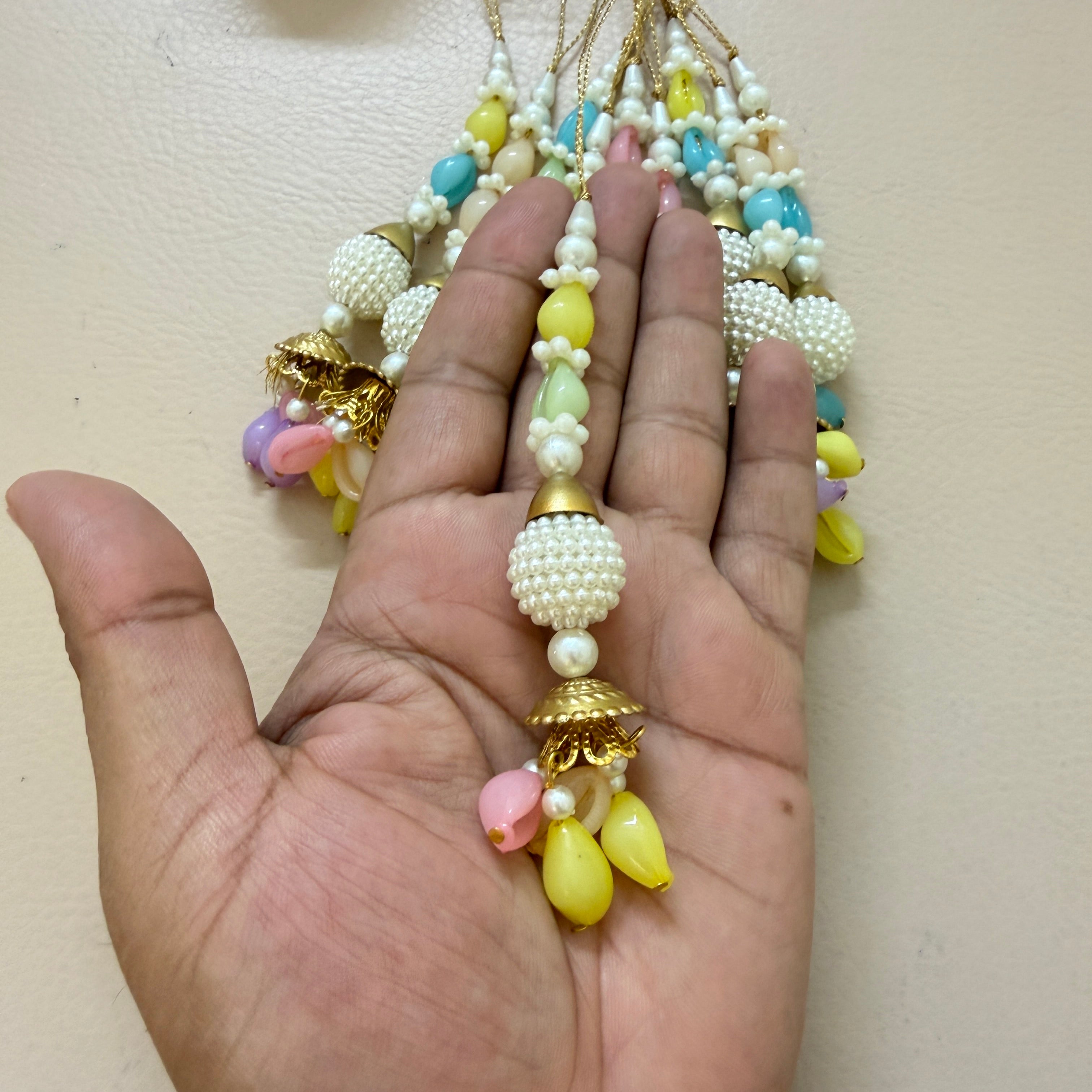 Colorful beaded necklace held in a hand against a beige background