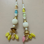 Pair of beaded earrings with gold accents on a light pink background