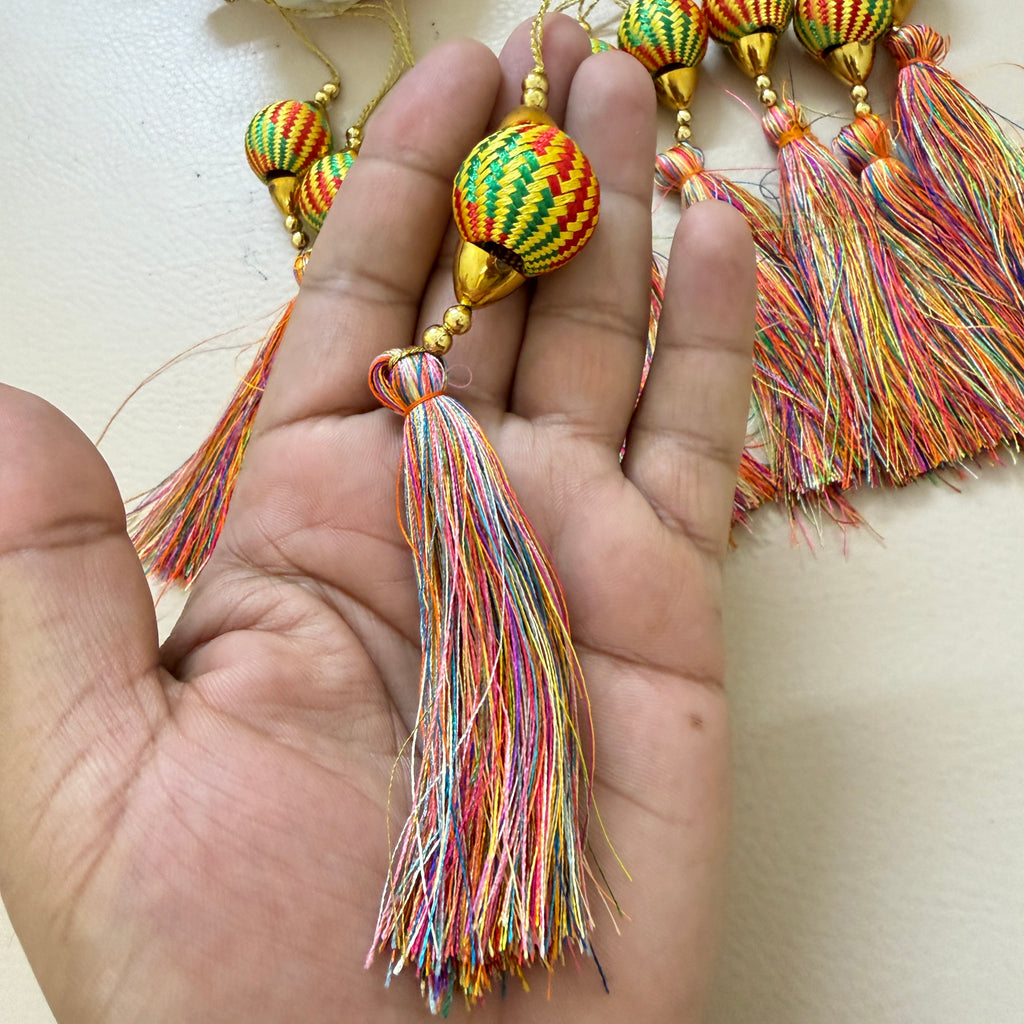 Colorful tassels with beads on a light background