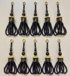 Set of black tassels with gold accents on a light gray background