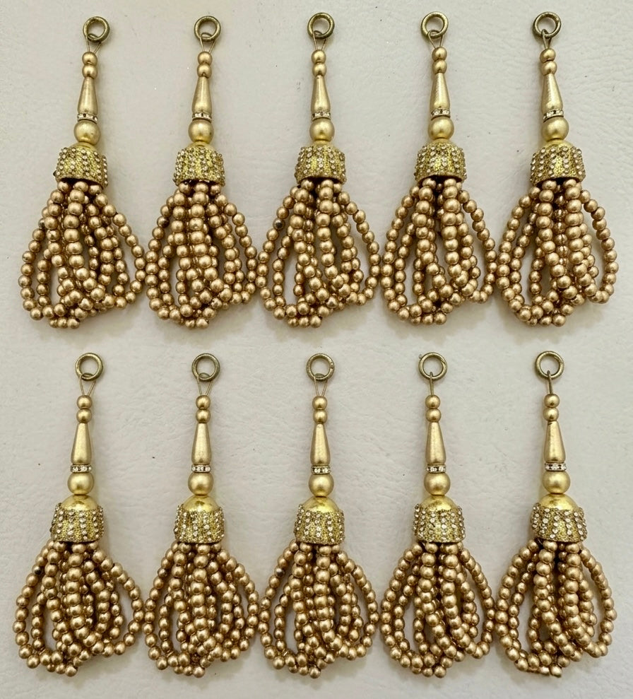 Gold tassels with beaded design on a white background
