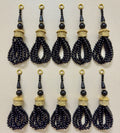Set of black beaded tassels with gold accents on a beige background