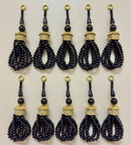 Set of black beaded tassels with gold accents on a beige background