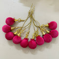 Pink tassel earrings with gold accents on a light background
