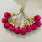 Pink tassel earrings with gold accents on a light background
