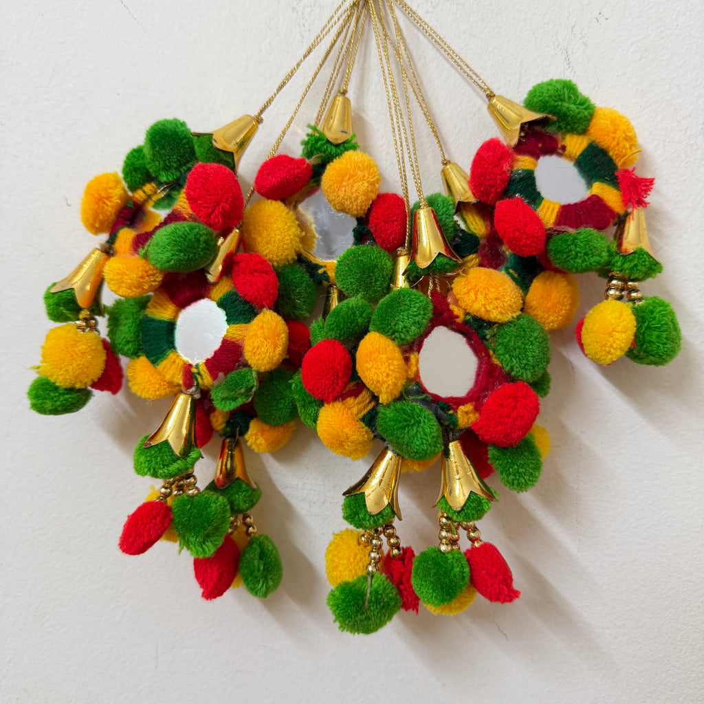 Colorful pom-pom earrings with gold accents on a white background