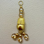 Gold tassel with beads on a beige background