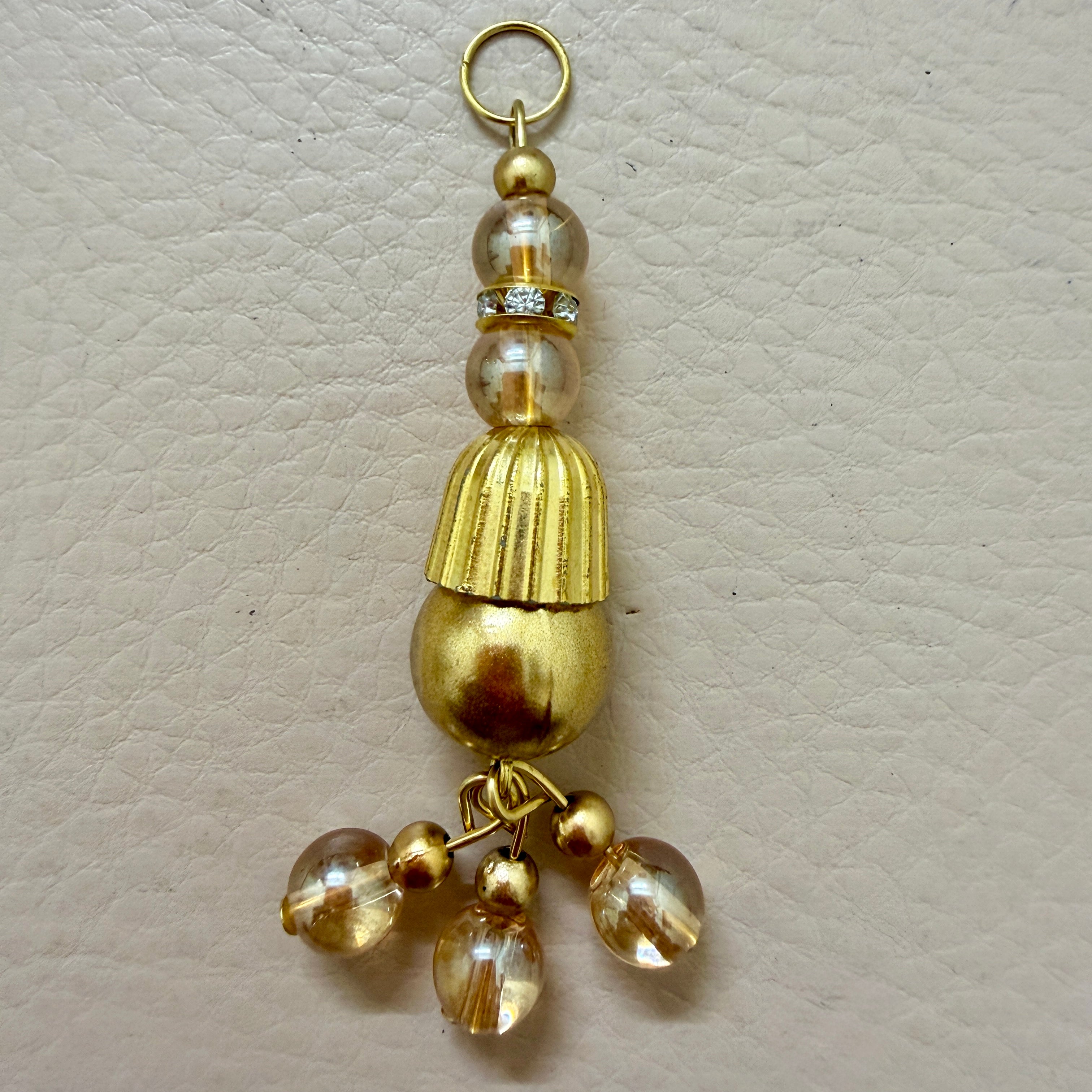 Gold tassel with beads on a beige background