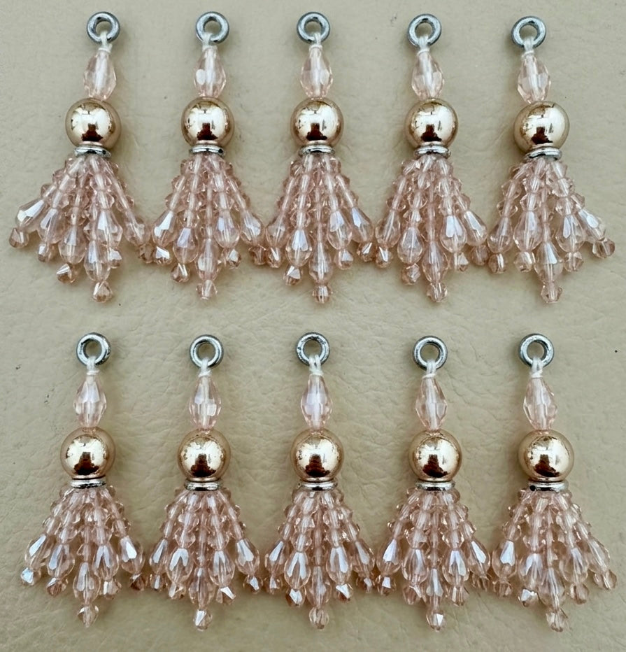 Set of beaded tassel charms on a beige background
