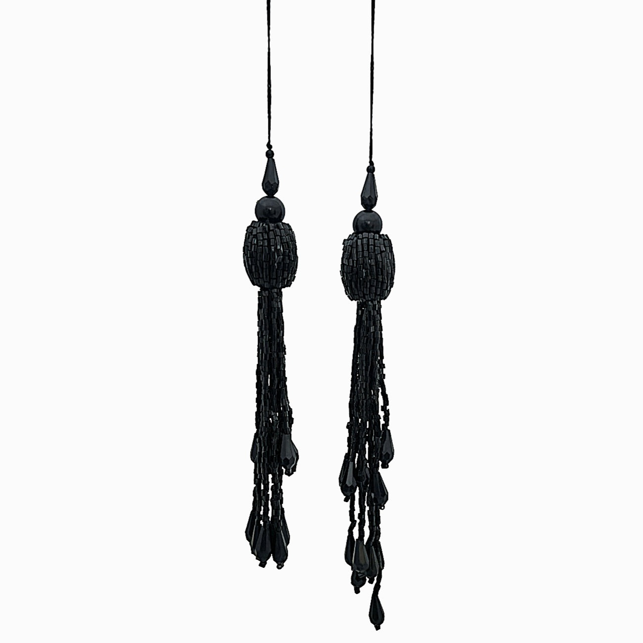 Pair of black tassel earrings on a white background