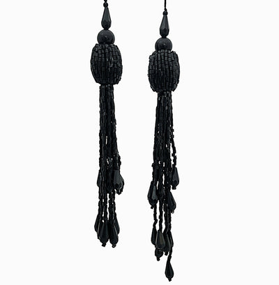 Pair of black beaded tassel earrings on a white background