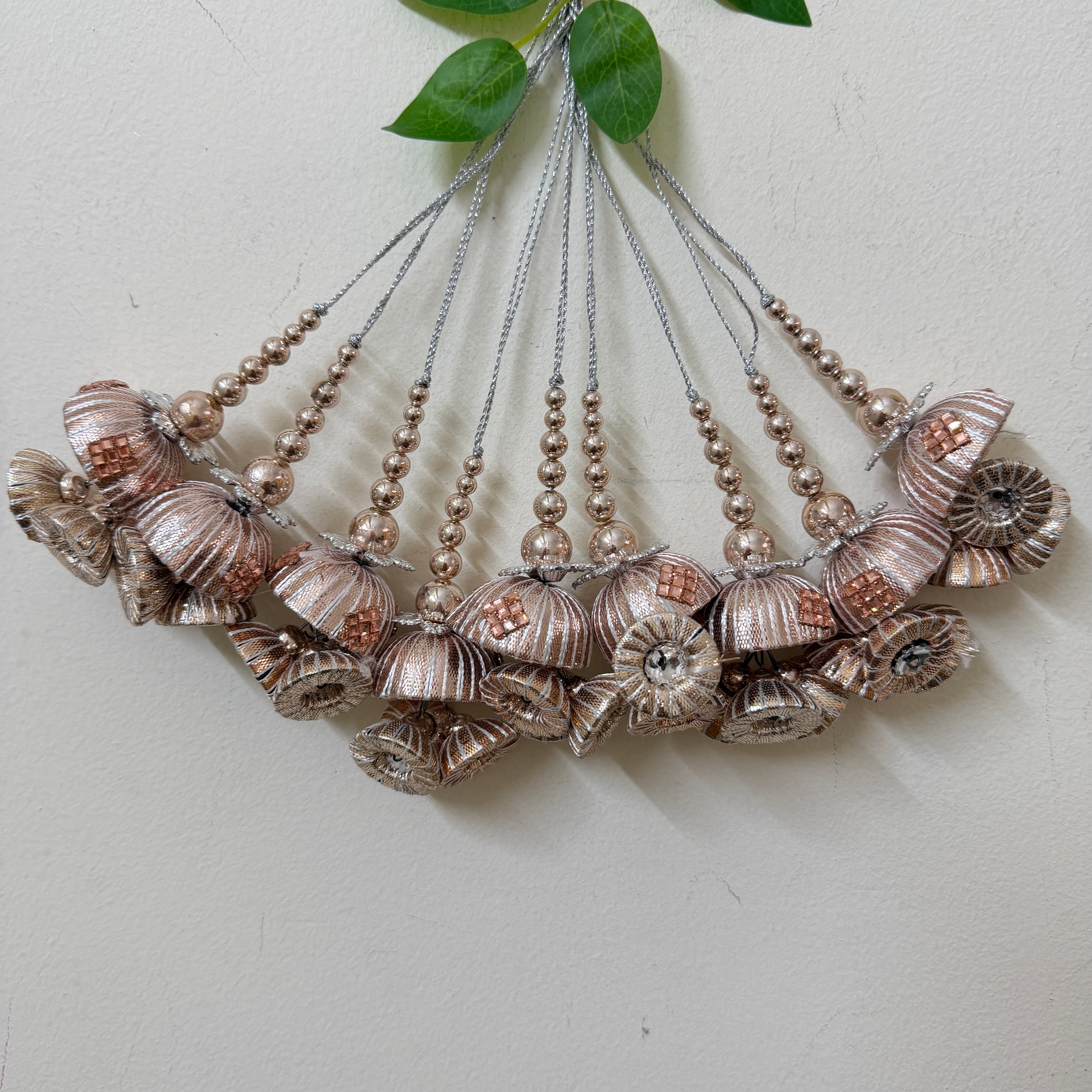 Decorative hanging with shell and bead design on a light background
