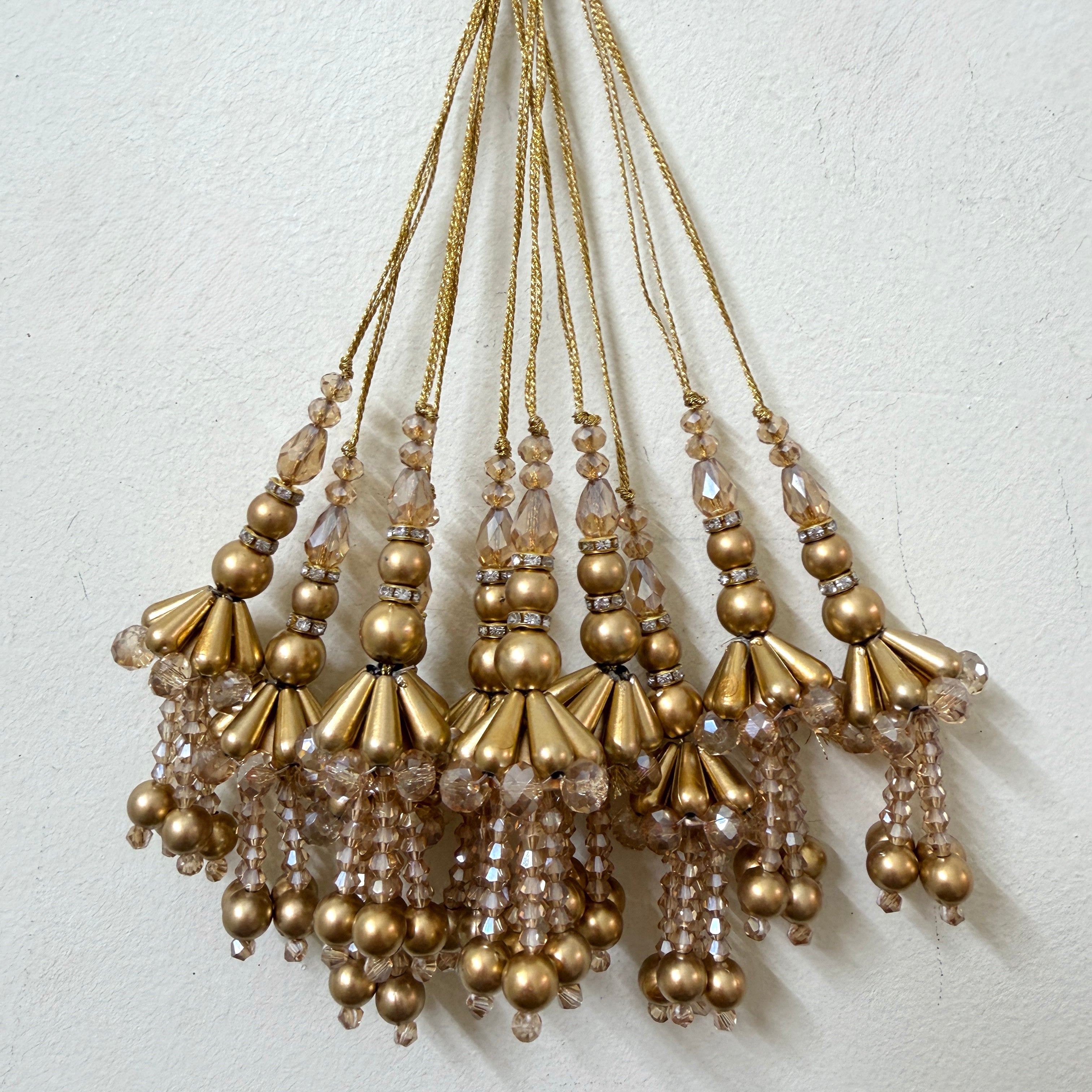 Set of gold beaded tassels on a light background