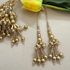 Gold beaded earrings with clear stones on a light background