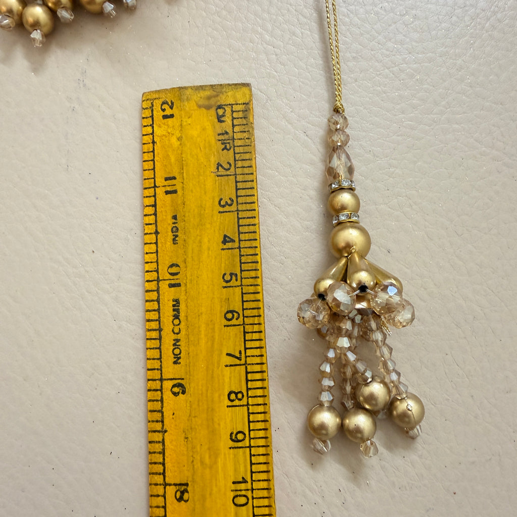 Jewelry with beads and crystals next to a ruler on a light background