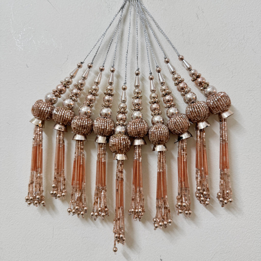 Decorative tassels with beads on a light gray background