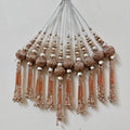 Decorative tassels with beads on a light gray background
