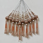 Decorative tassels with beads on a light gray background