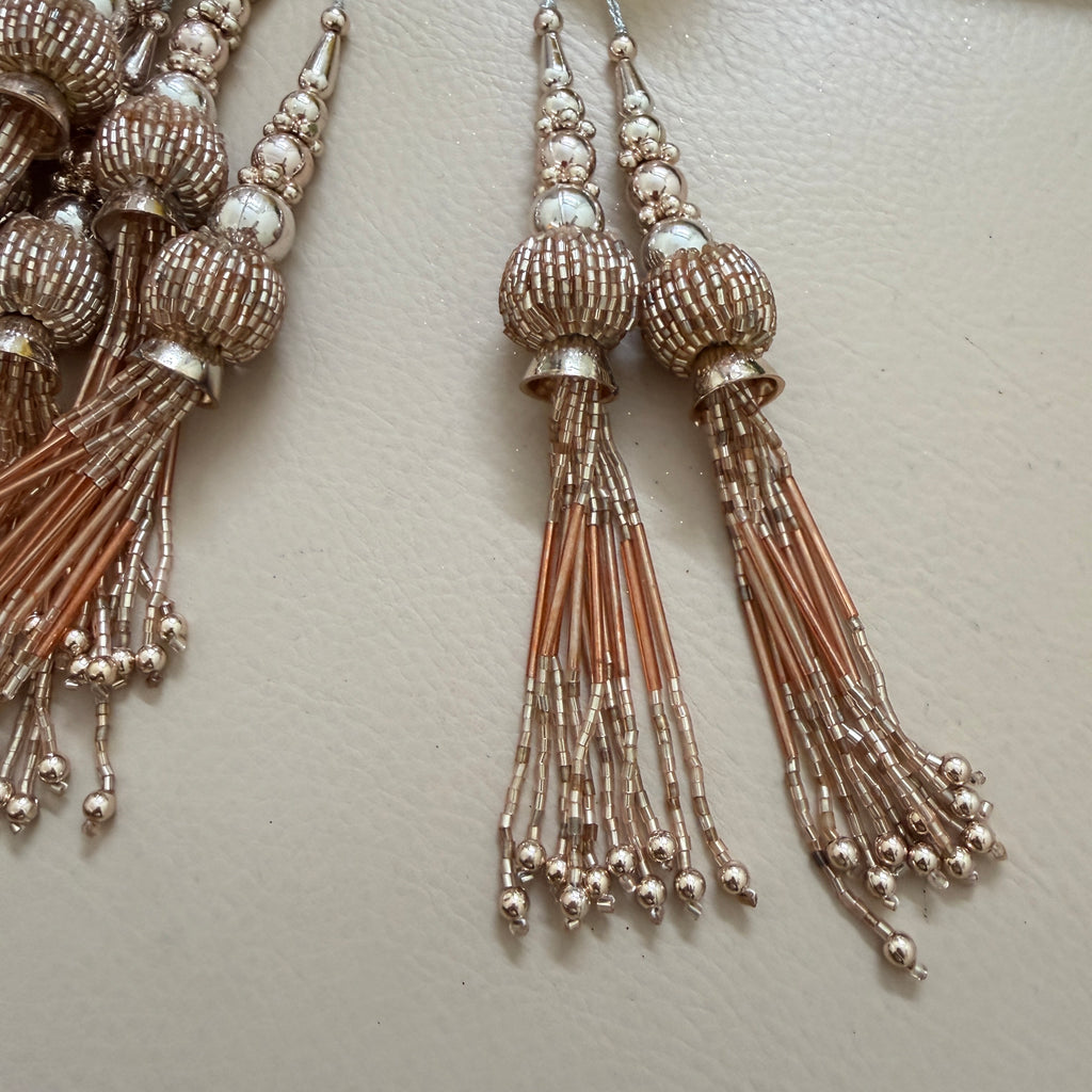 Decorative tassels with intricate beadwork on a light background