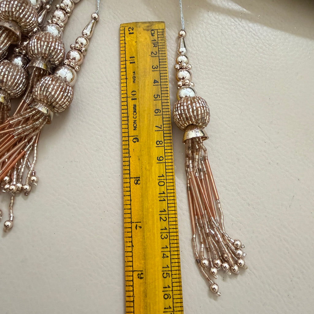 Decorative tassel with a ruler for scale on a light background