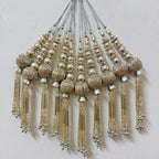 Decorative tassels with beads on a light gray background