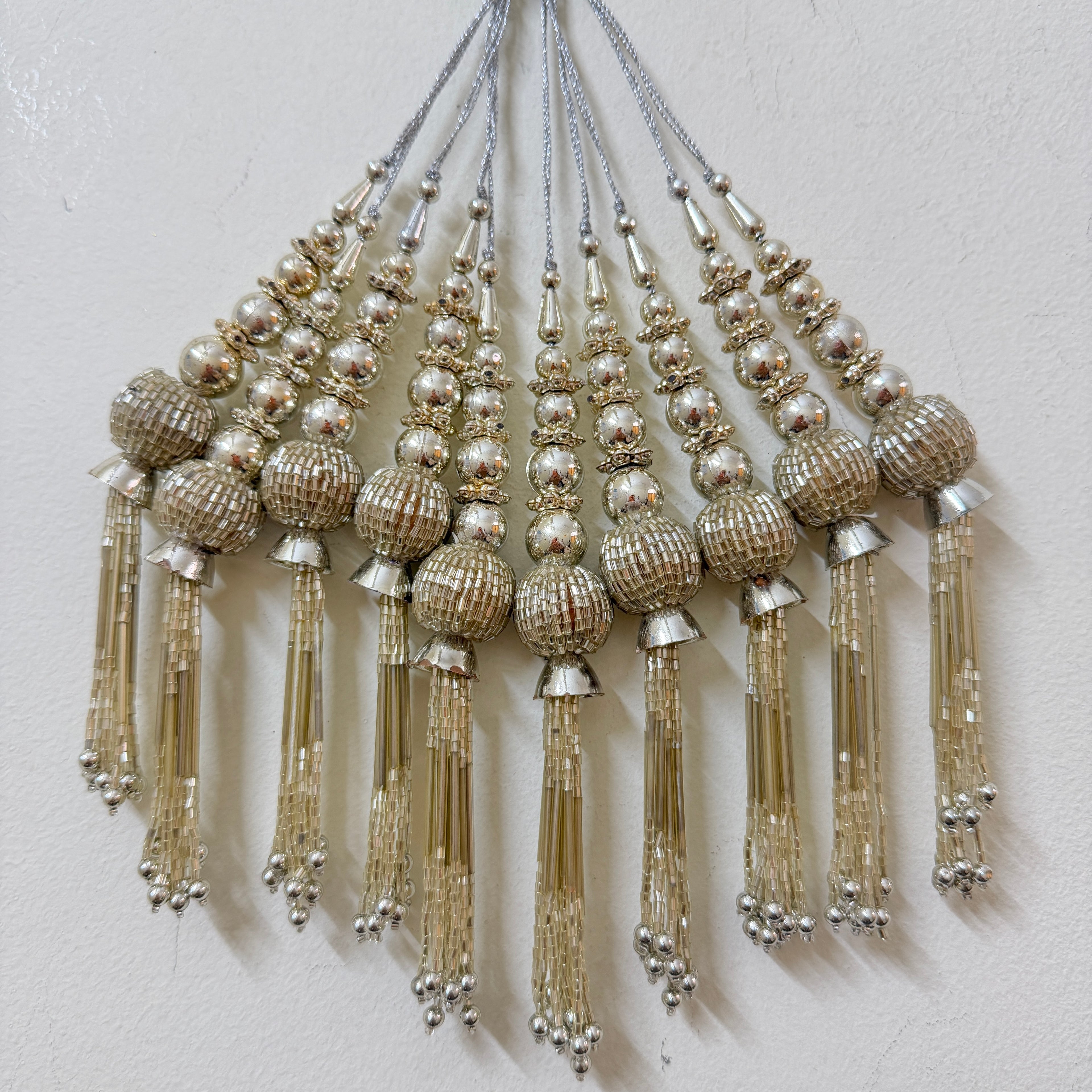 Decorative tassels with beads on a light gray background