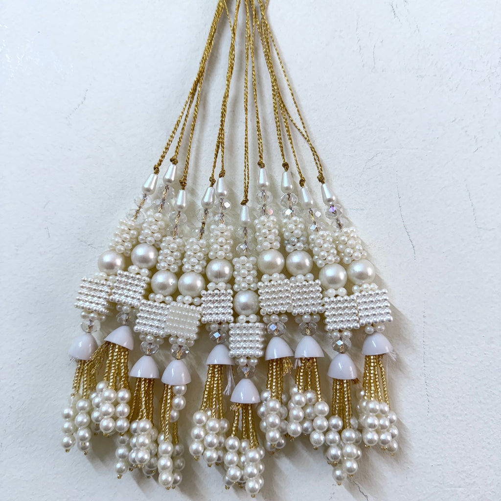 Set of pearl and gold tassel decorations on a white background