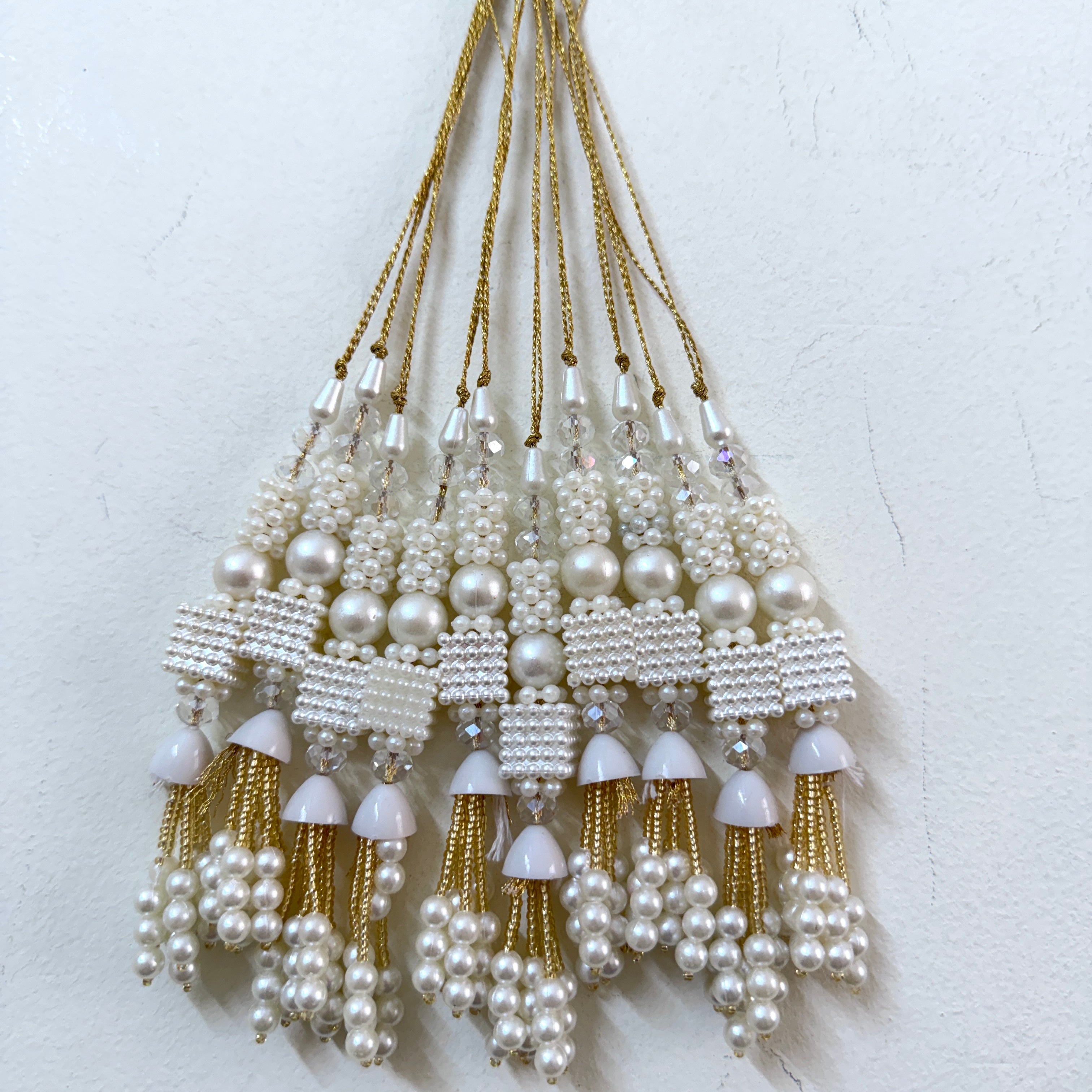 Set of pearl and gold tassel decorations on a white background