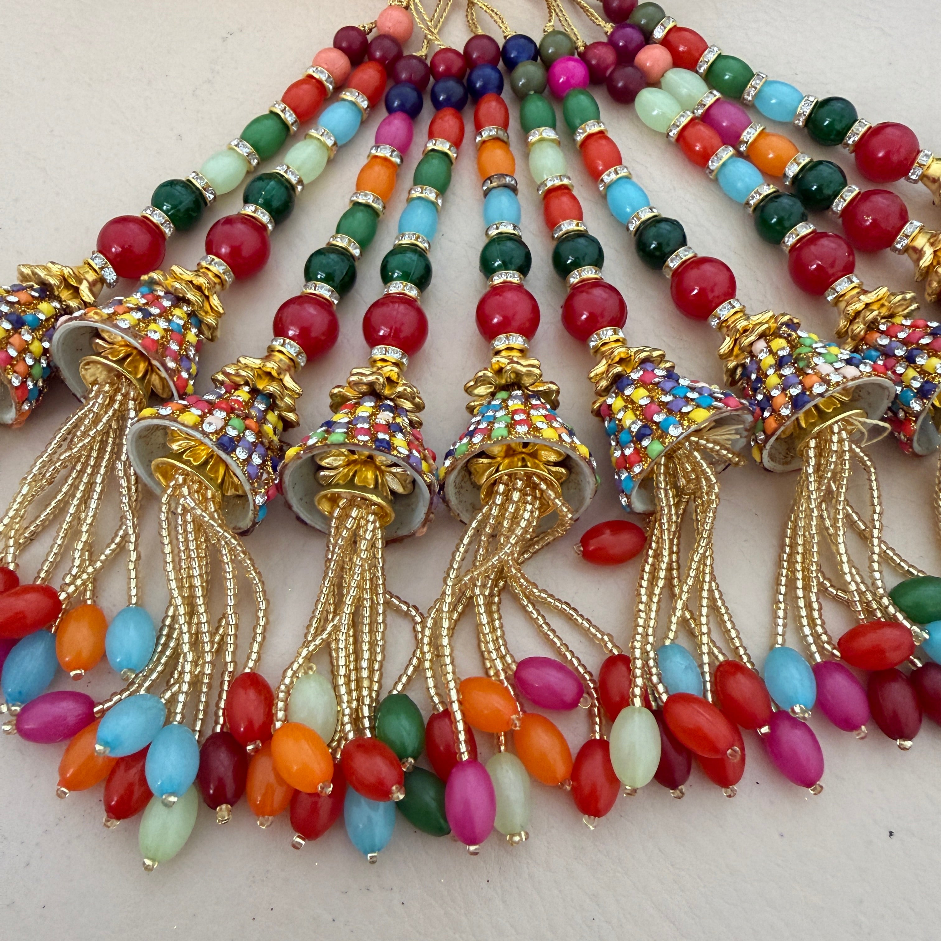 Colorful beaded tassels with gold accents on a light background