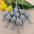 Silver beaded tassels with a beige background and yellow flowers.