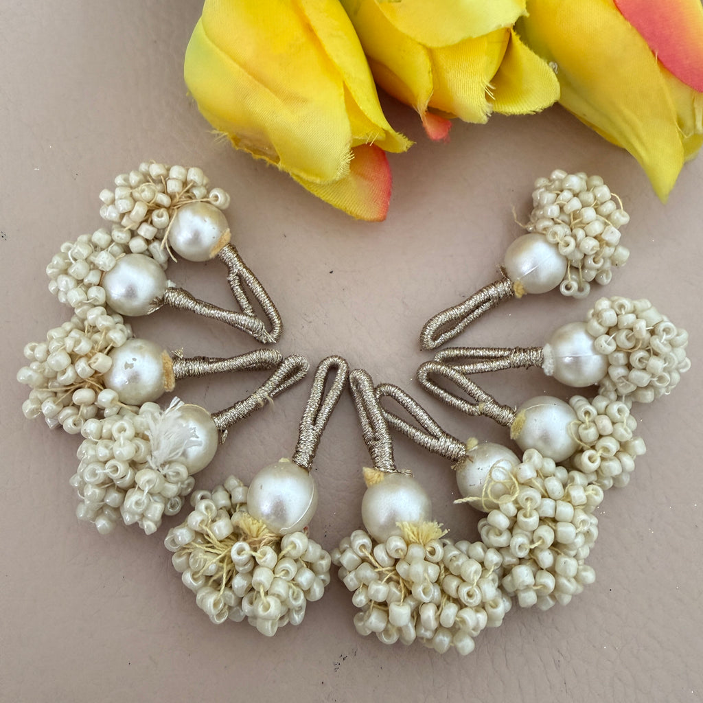 Set of pearl hair pins on a beige background with yellow flowers.