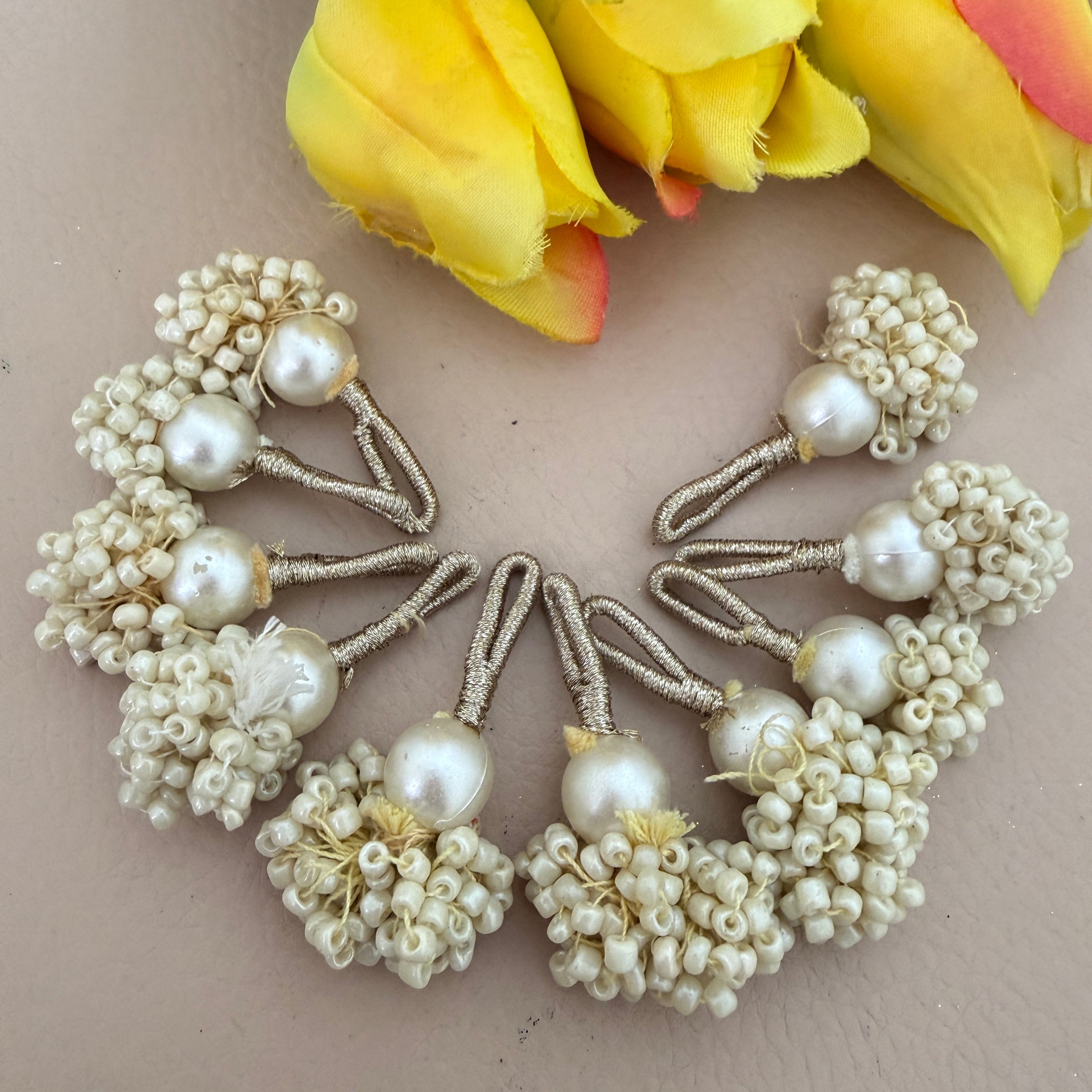 Set of pearl hair pins on a beige background with yellow flowers.