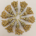 Gold tassels arranged in a circular pattern on a light background