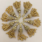 Gold tassels arranged in a circular pattern on a light background