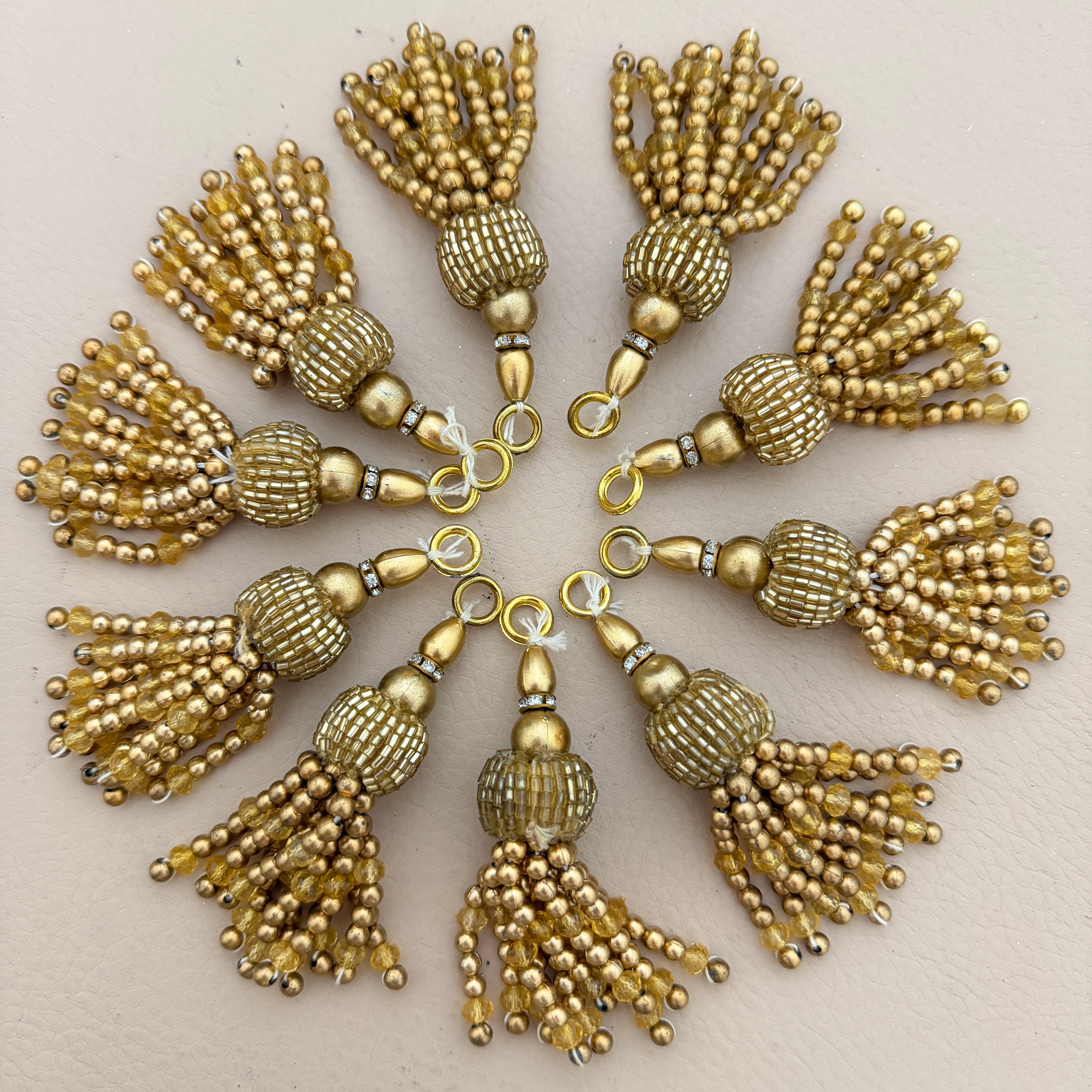 Gold tassels arranged in a circular pattern on a light background