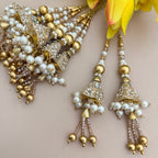 Gold and pearl earrings with floral decoration on a light background