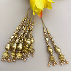 Gold earrings with pearl accents on a light background