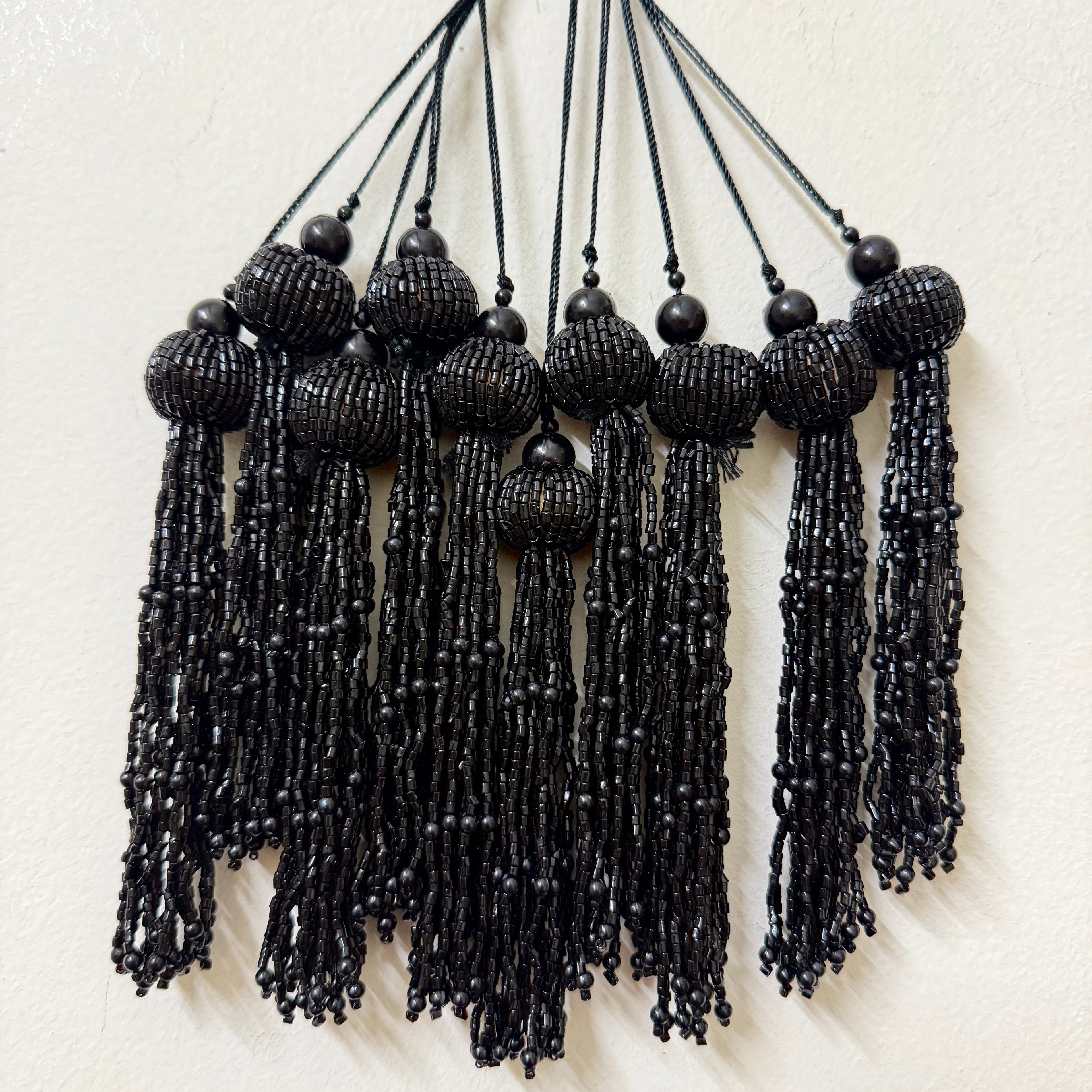 Black beaded tassel necklace on a white background