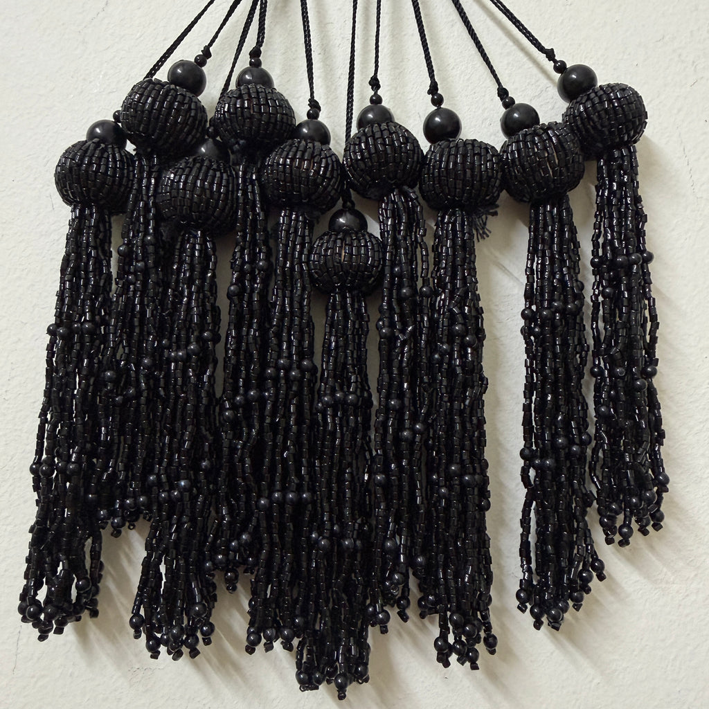 Black beaded tassels on a white background