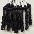 Black beaded tassels on a white background
