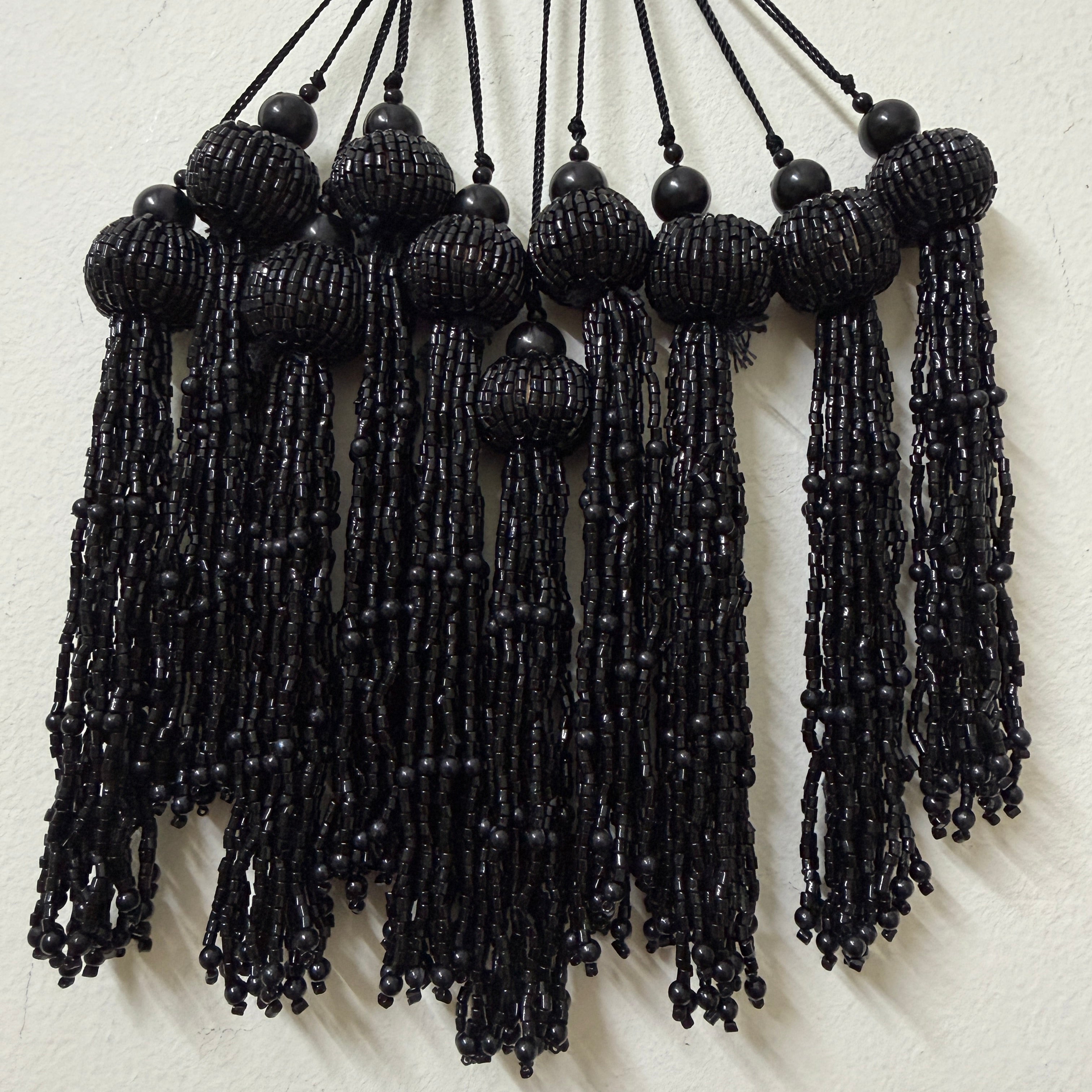 Black beaded tassels on a white background