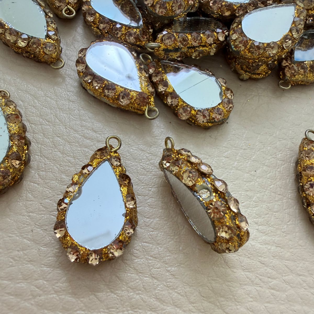 Champagne rhinestone teardrop mirror tassel shown beside ruler for size