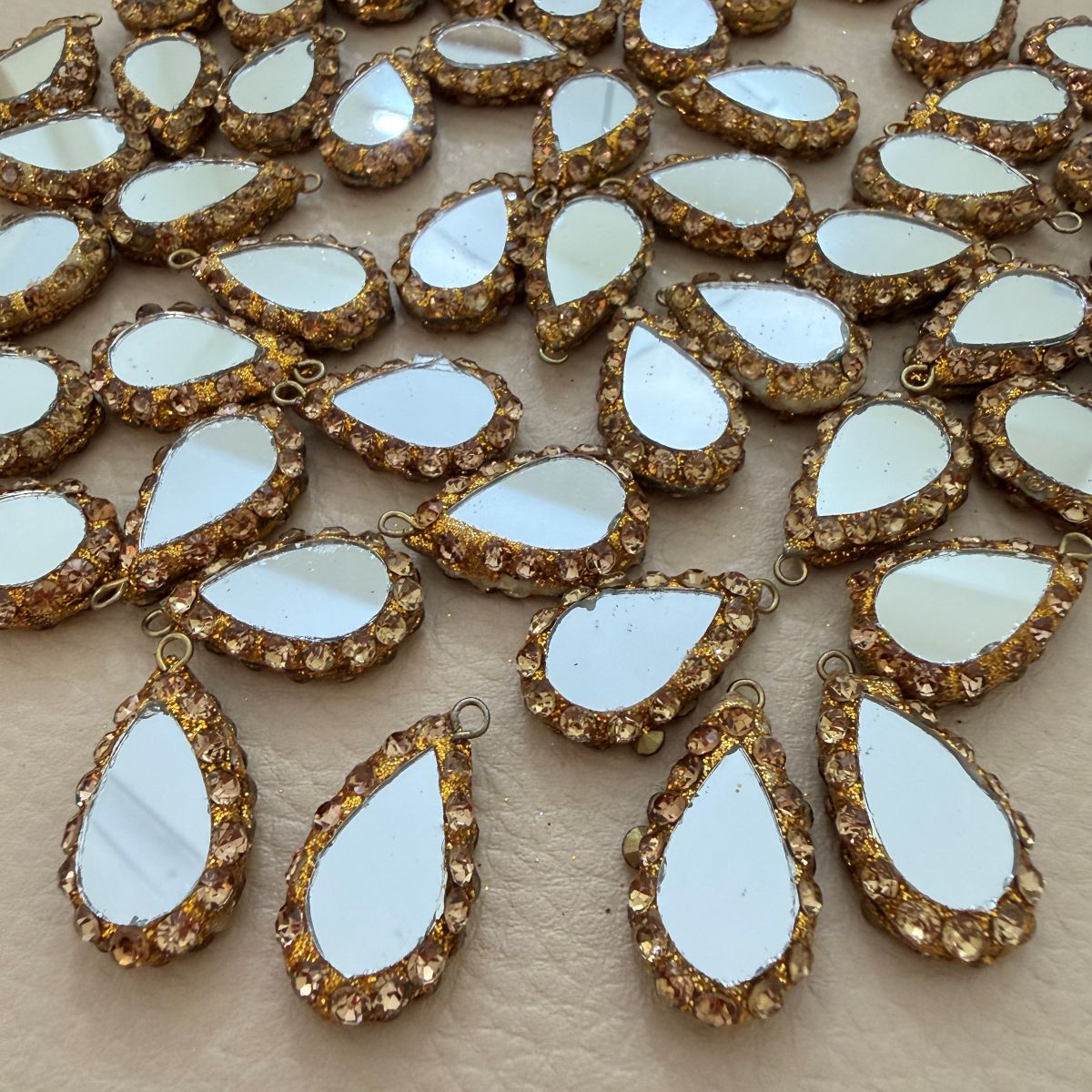 Pair of reflective teardrop tassels with sparkling champagne borders
