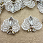 White pearl-effect and rhinestone fan patch held in hand