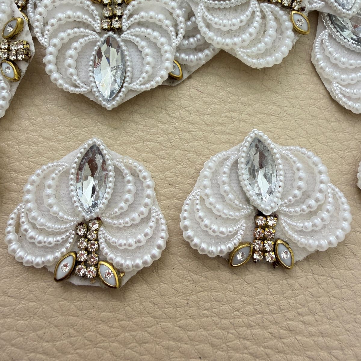 White pearl-effect and rhinestone fan patch held in hand