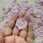 Pink marquise stone and white pearl-effect fan patch held in hand